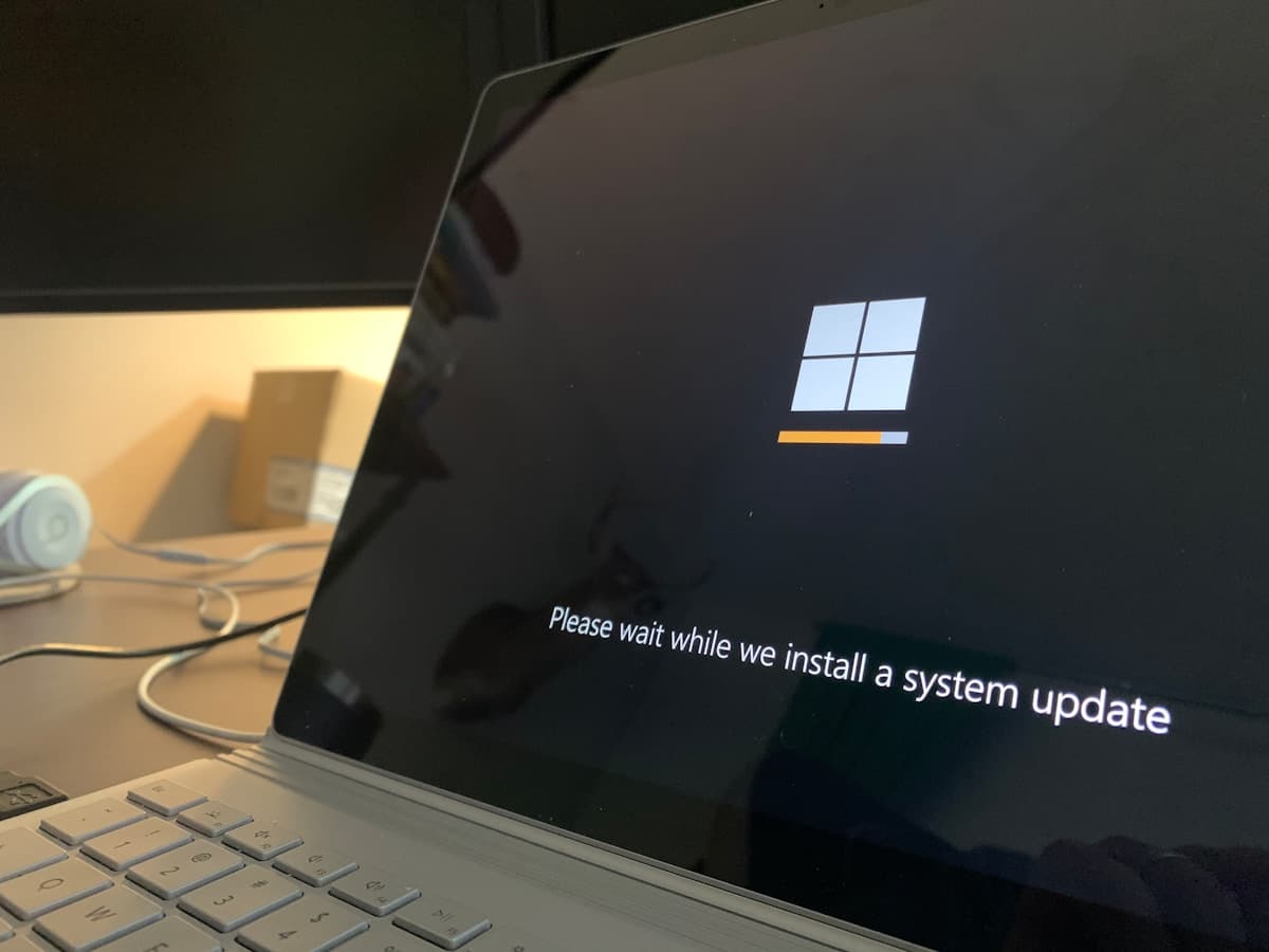 Laptop moderna abierta recibiendo actualizacion de Windows y certificados Secure Boot